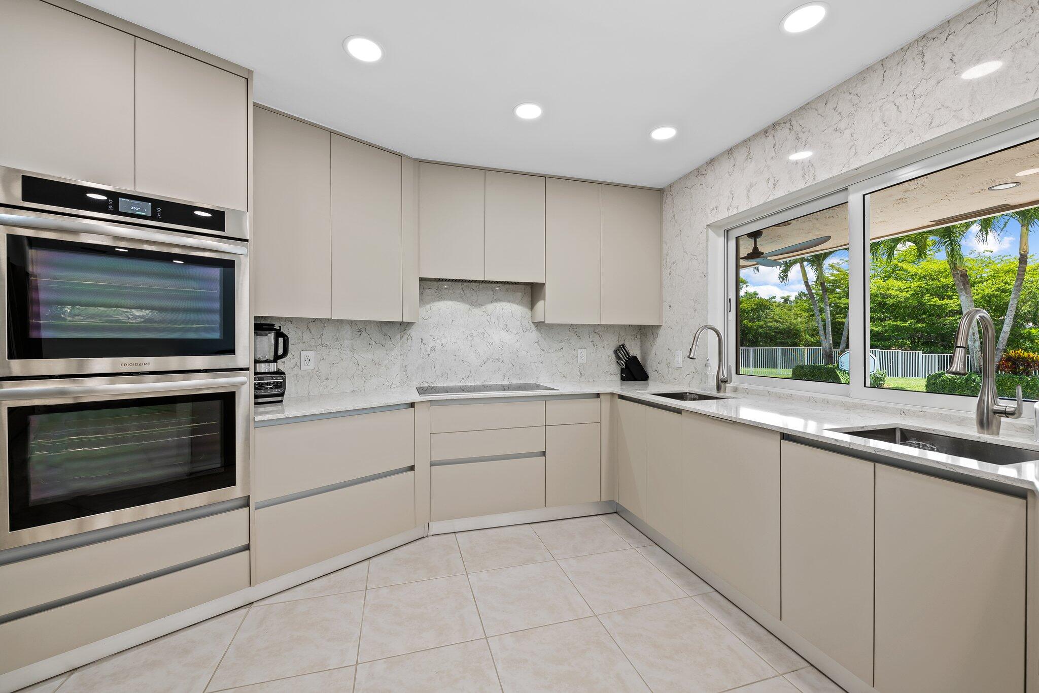 11937 Sandlake Drive Boca Raton, FL 33428 - Photo 21 of 54 a kitchen with granite countertop a stove sink and microwave