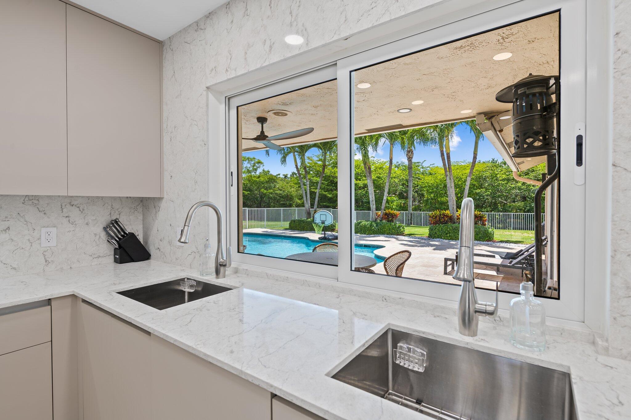 11937 Sandlake Drive Boca Raton, FL 33428 - Photo 22 of 54 a kitchen with a sink and a large window