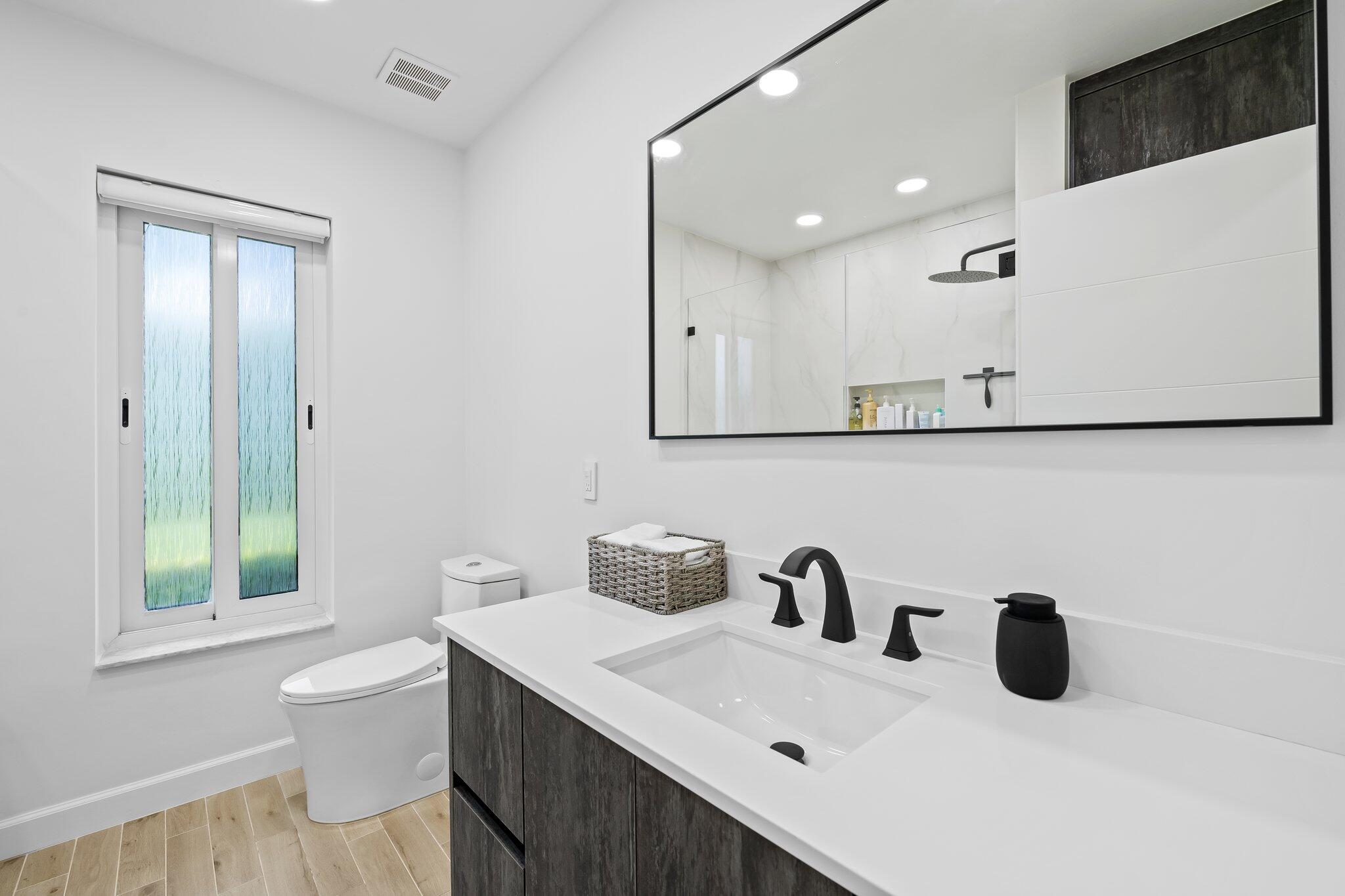 11937 Sandlake Drive Boca Raton, FL 33428 - Photo 34 of 54 a bathroom with a sink a toilet and a mirror