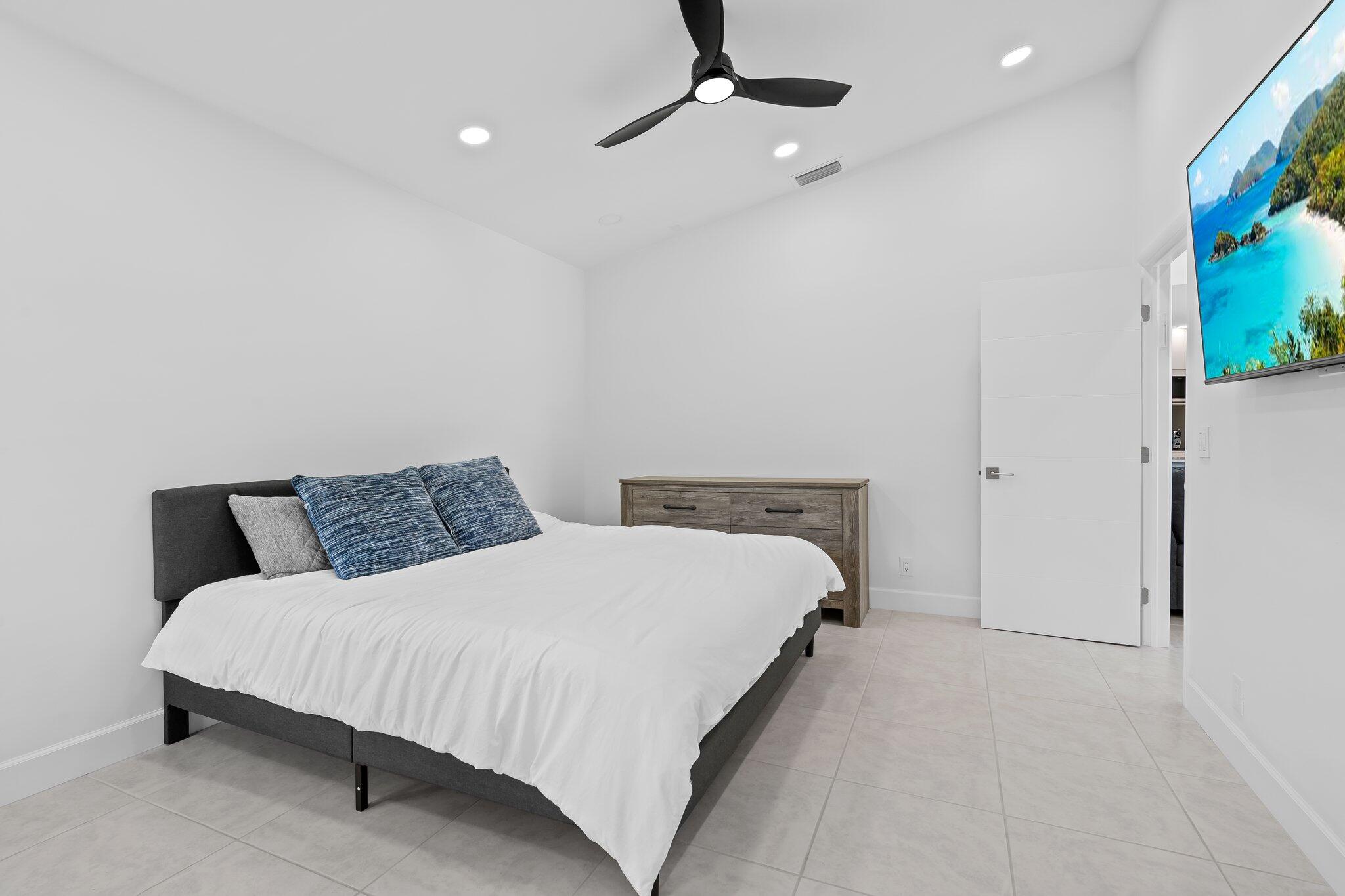 11937 Sandlake Drive Boca Raton, FL 33428 - Photo 42 of 54 a bedroom with double bed and a flat tv screen