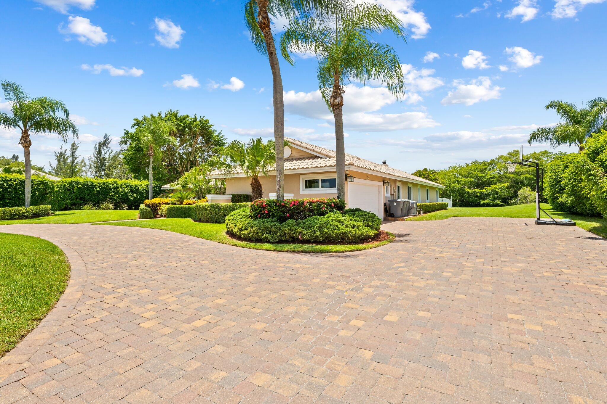 11937 Sandlake Drive Boca Raton, FL 33428 - Photo 8 of 54 a front view of a house with a yard and palm trees