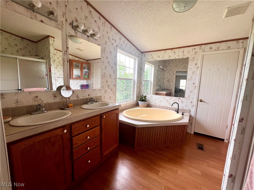 8548 Mount Carmel Rdg Road St. Marys, WV 26170 - Photo 19 of 30 Full bathroom with wallpapered walls, ornamental molding, a textured ceiling, a stall shower, and a garden tub