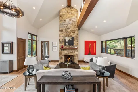 a living room with fireplace furniture and floor to ceiling windows
