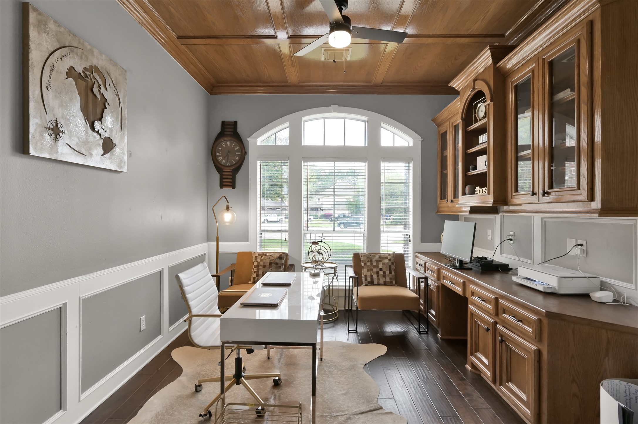 9706 Chipstead Court Spring, TX 77379 - Photo 7 of 44 Discover an executive worthy office space beyond the staircase, featuring wood cabinetry, a sophisticated desk setup, and a bright window for natural light.
