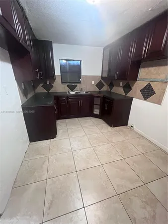 a kitchen with granite countertop a sink a stove and a microwave