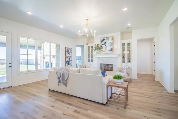 a living room with furniture a fireplace and wooden floor