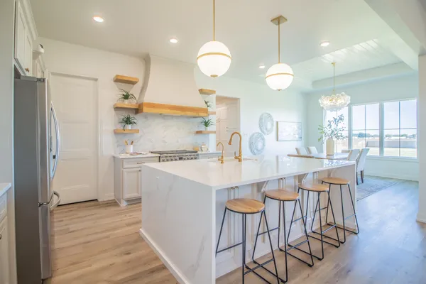 a kitchen with a dining table chairs a sink and a refrigerator