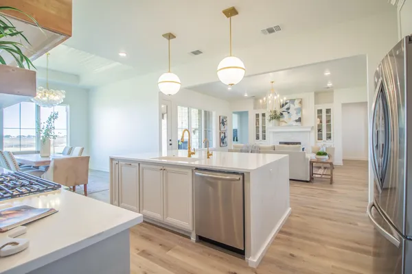 a large kitchen with kitchen island a stove a sink a refrigerator and a view of living room