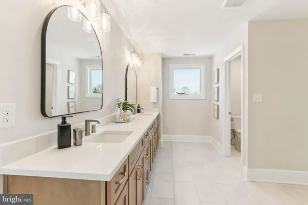 a bathroom with a granite countertop double vanity sink and mirror
