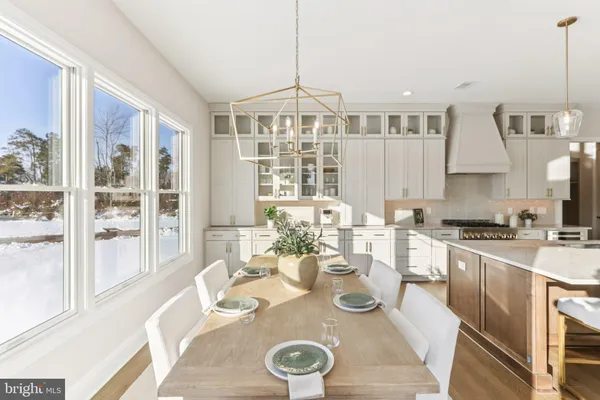 a kitchen with stainless steel appliances granite countertop a stove a sink a kitchen island with chairs and cabinets