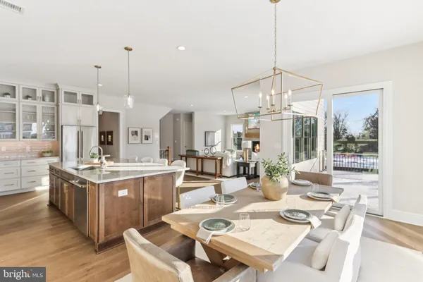 a view of a dining room and livingroom with furniture wooden floor a chandelier