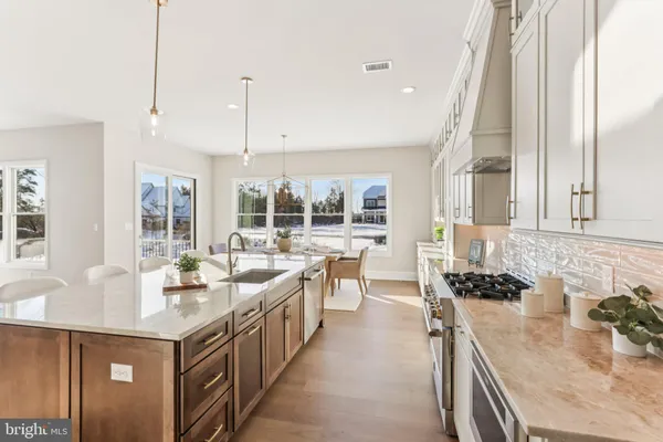 a large kitchen with kitchen island a large window a sink and stainless steel appliances