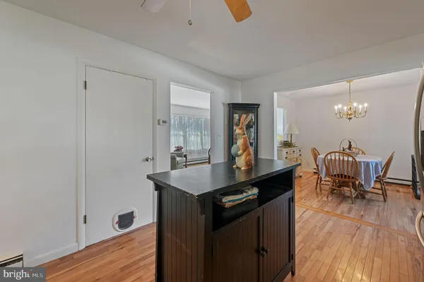 a kitchen with granite countertop a table chairs stove and wooden floor
