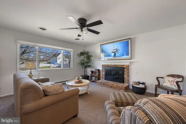 a living room with furniture ceiling fan and a fireplace