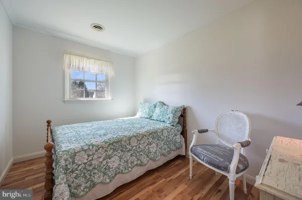 a bedroom with a bed chair and window