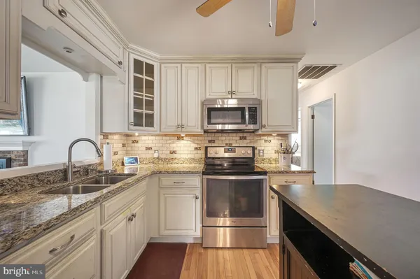 a kitchen with a sink stove top oven and refrigerator