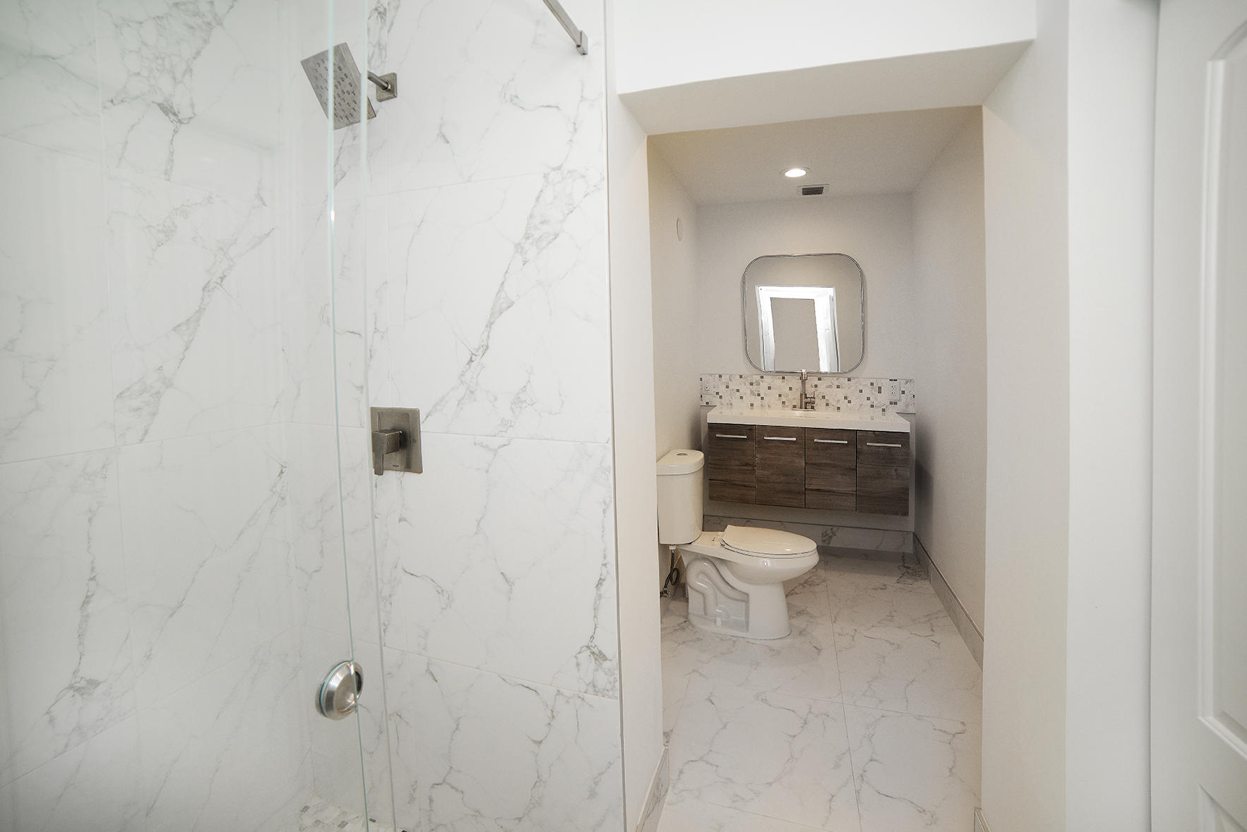 200 Southwest 2nd Street Boca Raton, FL 33432 - Photo 15 of 26 a bathroom with a toilet a sink and mirror