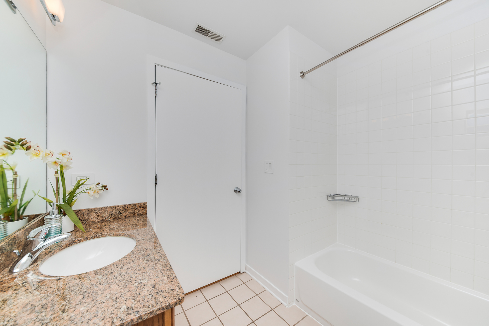 4350 North Broadway, Unit 607 Chicago, IL 60613 - Photo 12 of 18 a bathroom with a granite countertop sink and a mirror