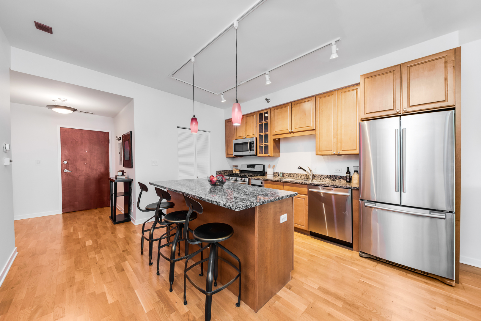 4350 North Broadway, Unit 607 Chicago, IL 60613 - Photo 6 of 18 a kitchen with stainless steel appliances granite countertop a refrigerator a sink dishwasher a stove with white cabinets and wooden floor