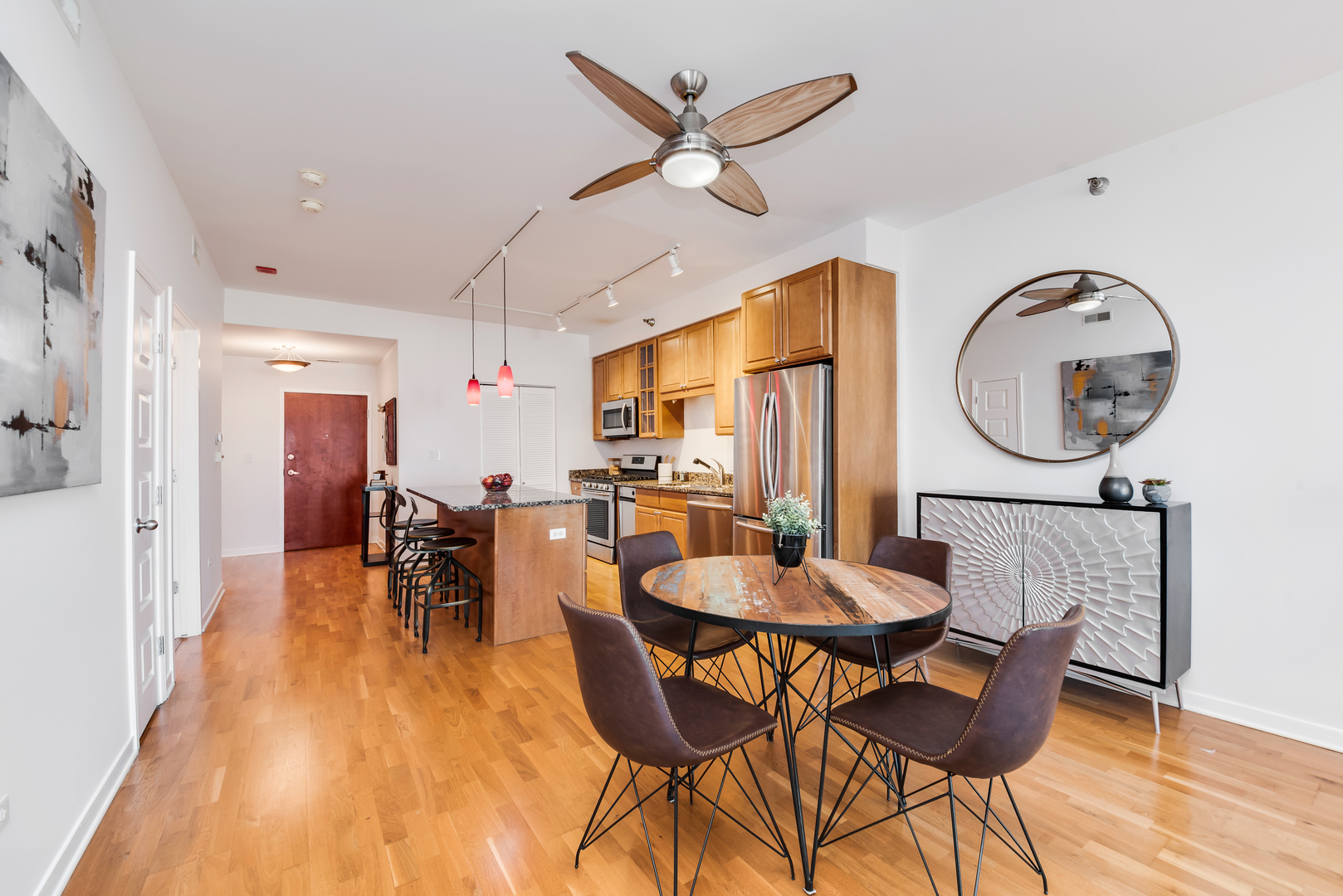 4350 North Broadway, Unit 607 Chicago, IL 60613 - Photo 8 of 18 a dining room with furniture a rug a flat screen tv and a clock