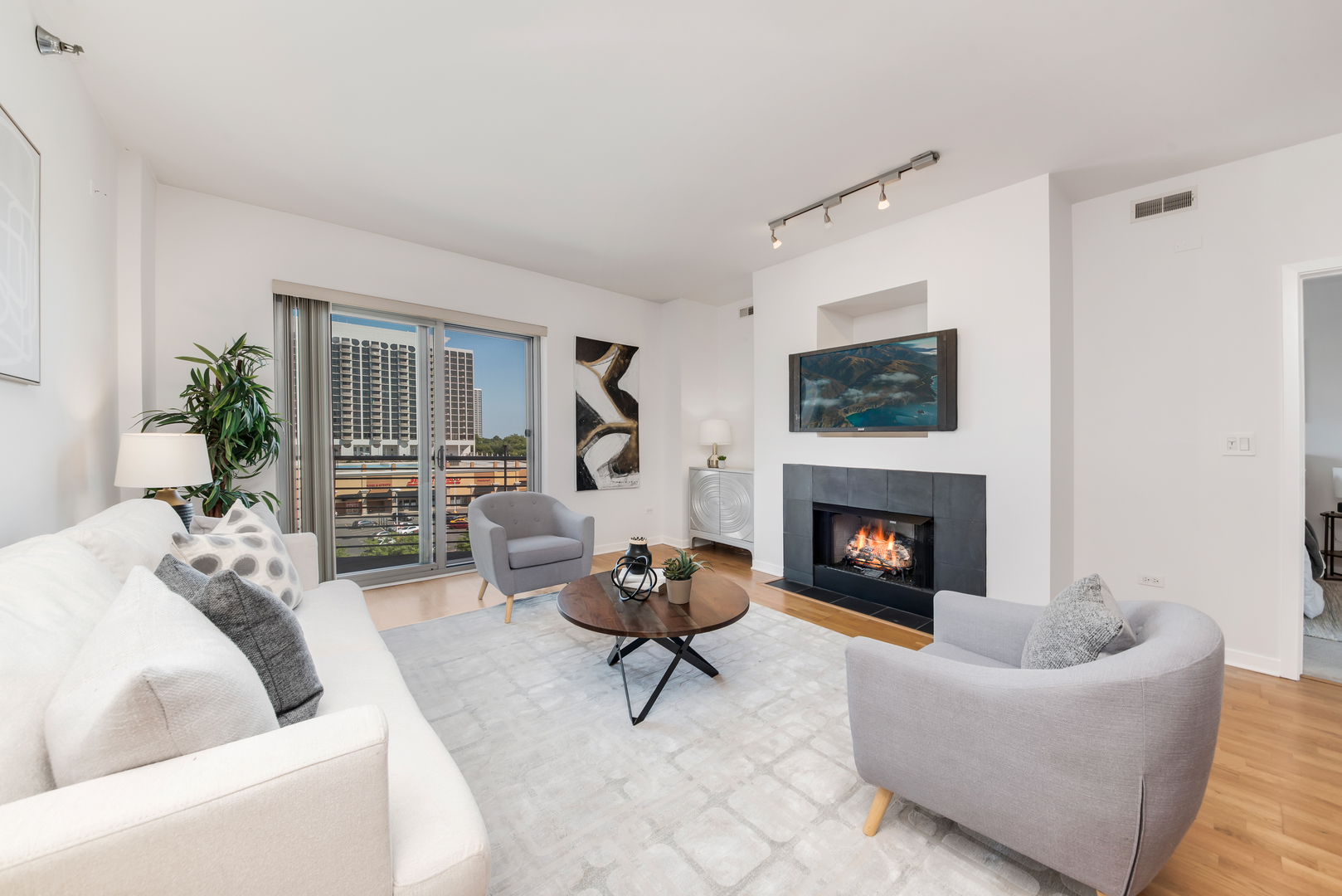 4350 North Broadway, Unit 607 Chicago, IL 60613 - Photo 10 of 18 a living room with furniture a fireplace and a potted plant