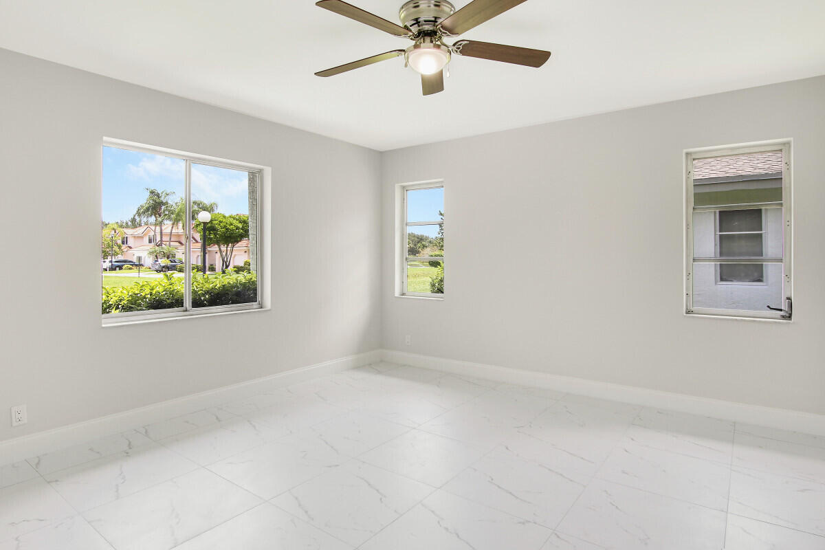 8641 Sunbird Place Boca Raton, FL 33496 - Photo 13 of 24 an empty room with windows and ceiling fan