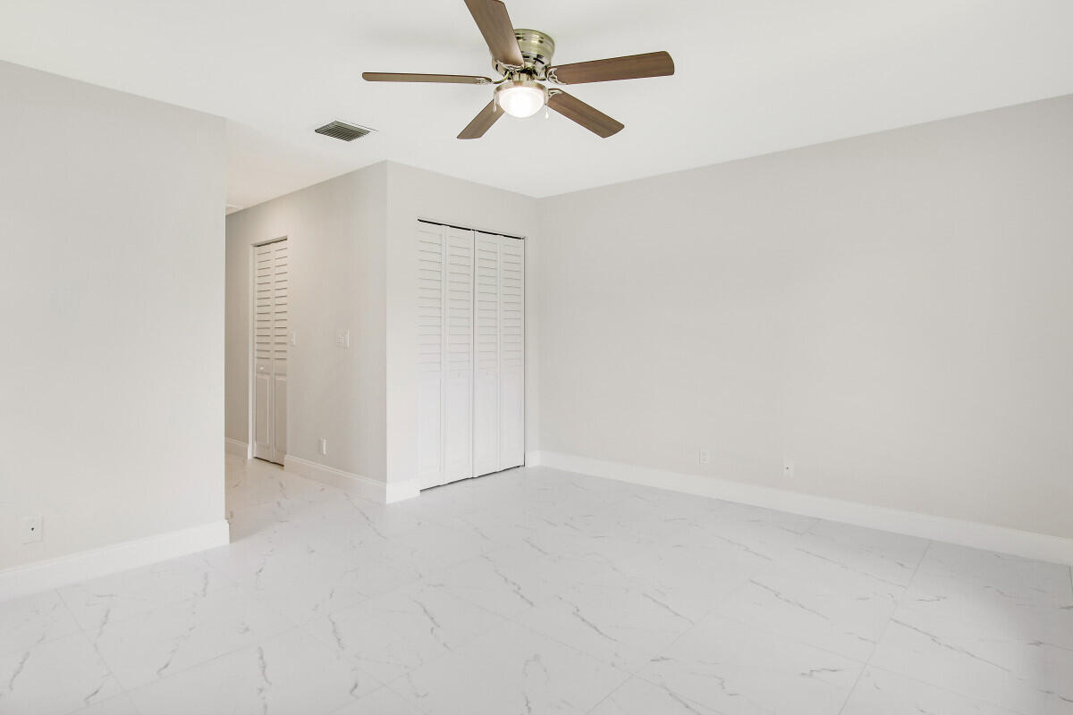8641 Sunbird Place Boca Raton, FL 33496 - Photo 14 of 24 an empty room with chandelier fan