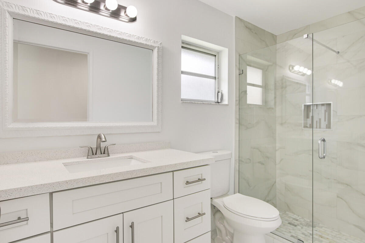 8641 Sunbird Place Boca Raton, FL 33496 - Photo 15 of 24 a bathroom with a sink toilet vanity and shower