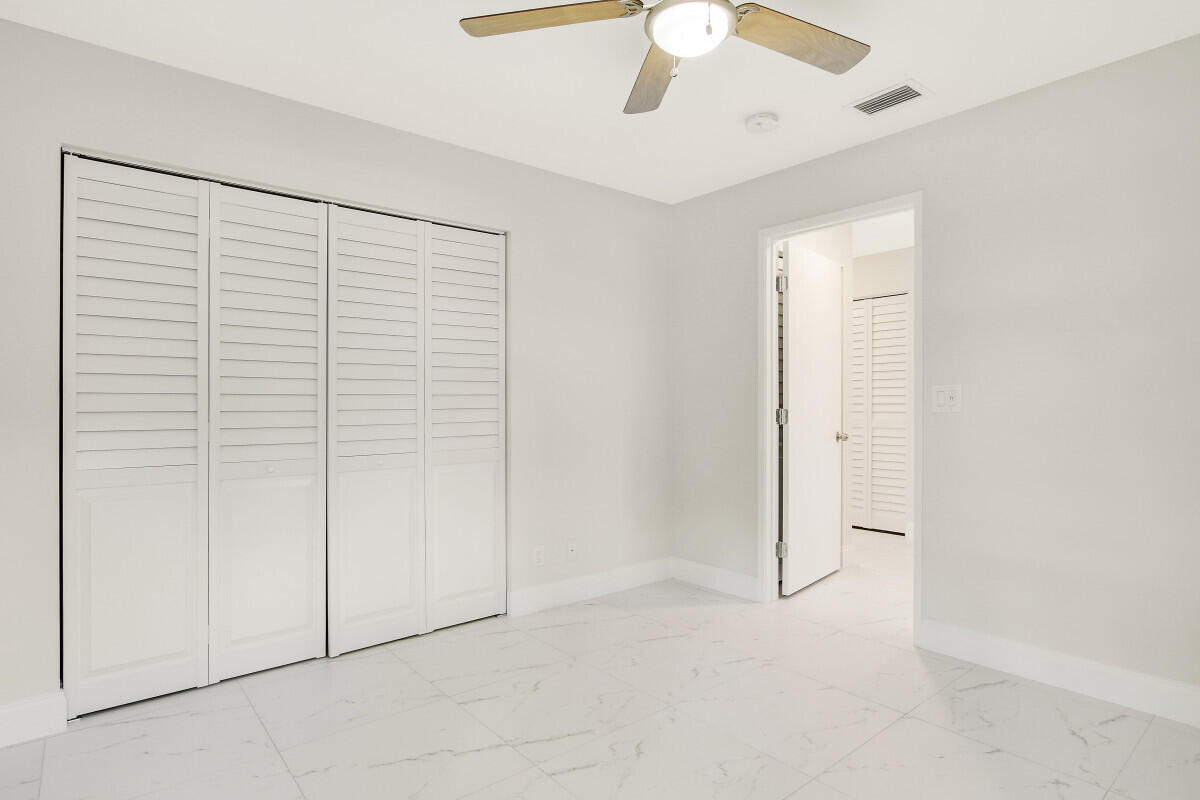 8641 Sunbird Place Boca Raton, FL 33496 - Photo 18 of 24 an empty room with a ceiling fan