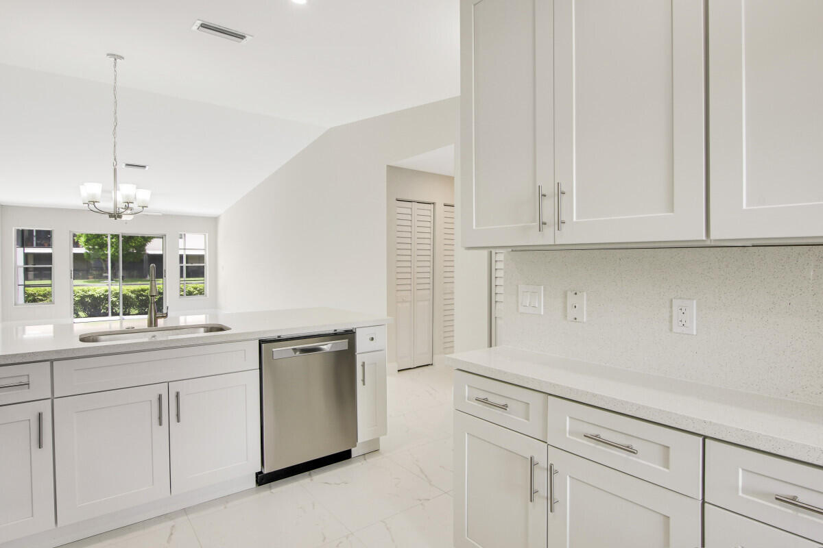 8641 Sunbird Place Boca Raton, FL 33496 - Photo 10 of 24 a kitchen with white cabinets and a sink