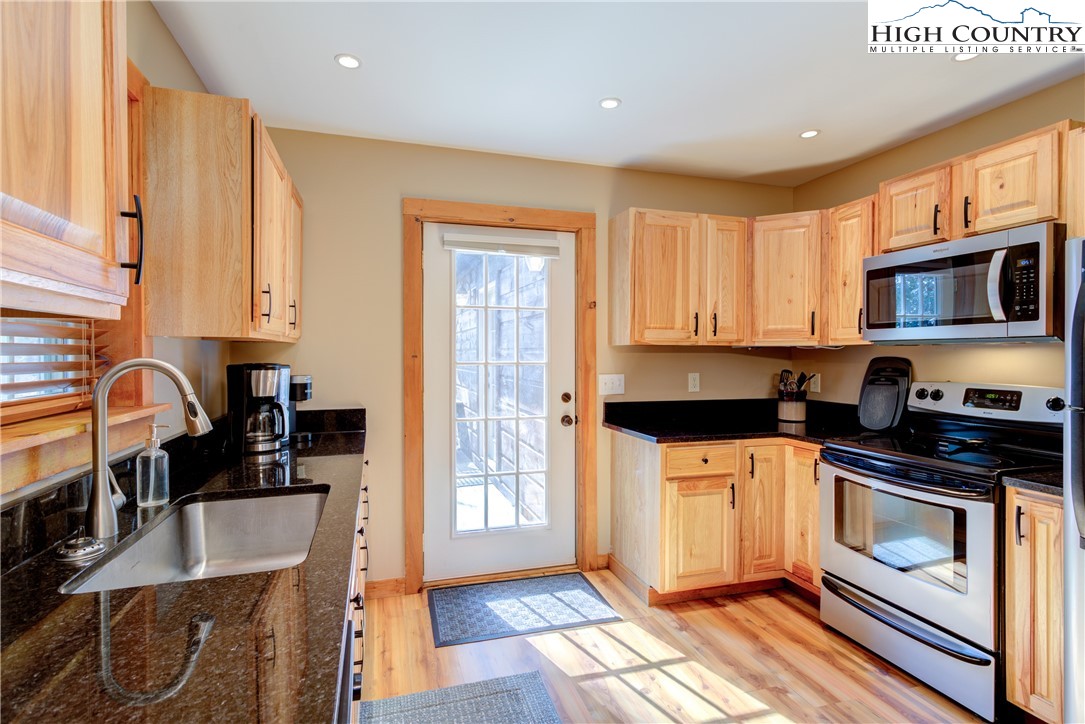 256 Holiday Hills Drive Boone, NC 28607 - Photo 16 of 34 a kitchen with stainless steel appliances granite countertop a stove a sink dishwasher and a microwave oven with cabinets
