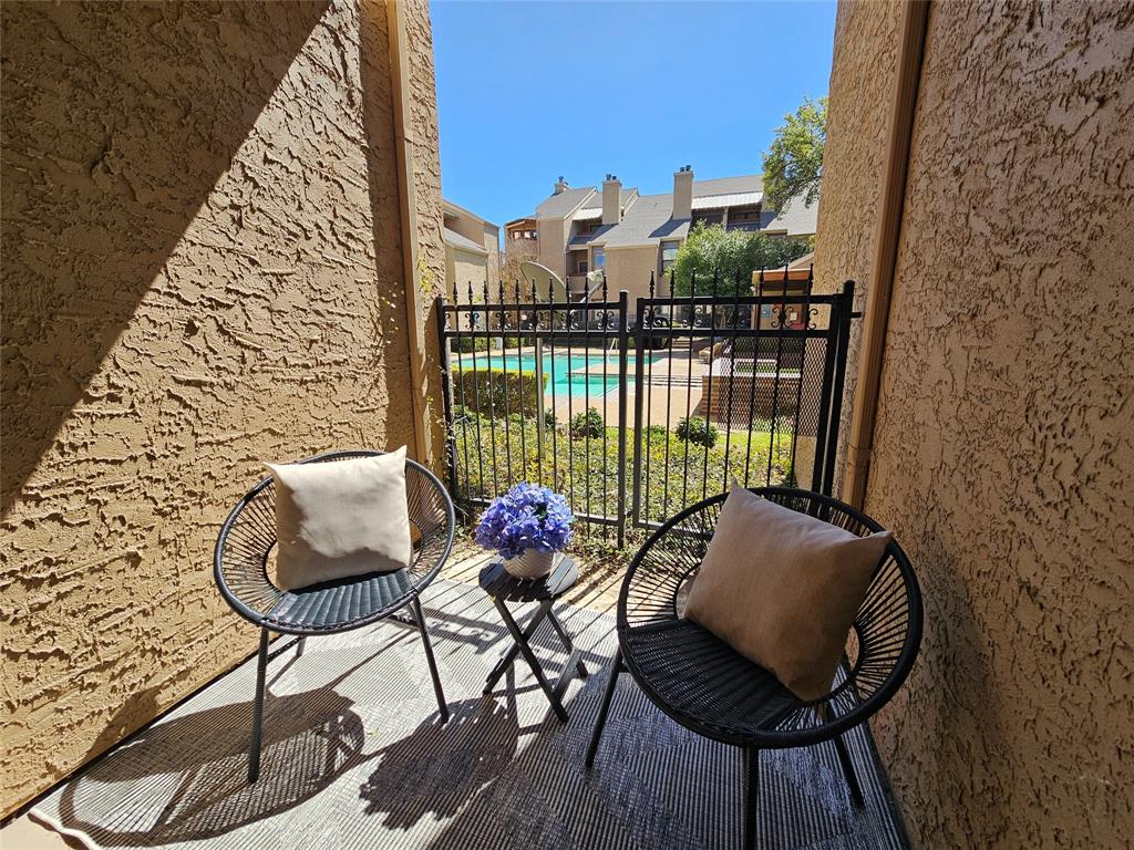 5550 Spring Valley Road, Unit C14 Dallas, TX 75254 - Photo 15 of 21 Private patio featuring textured stucco walls and a woven area rug