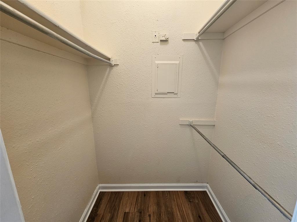 5550 Spring Valley Road, Unit C14 Dallas, TX 75254 - Photo 21 of 21 Functional closet space featuring wood-finish flooring, white baseboards, and textured walls