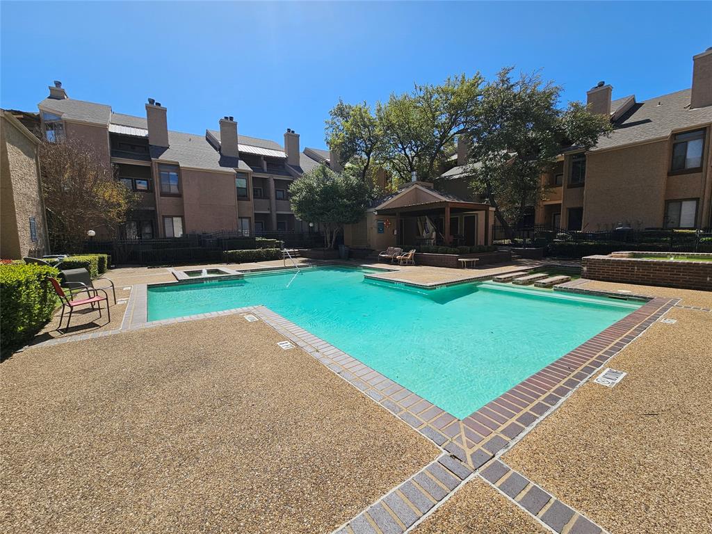 5550 Spring Valley Road, Unit C14 Dallas, TX 75254 - Photo 4 of 21 Expansive outdoor swimming pool with surrounding aggregate concrete decking and brick border