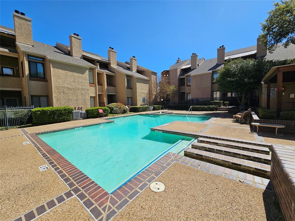 5550 Spring Valley Road, Unit C14 Dallas, TX 75254 - Photo 5 of 21 Community pool featuring a large swimming area, integrated spa, and brick coping