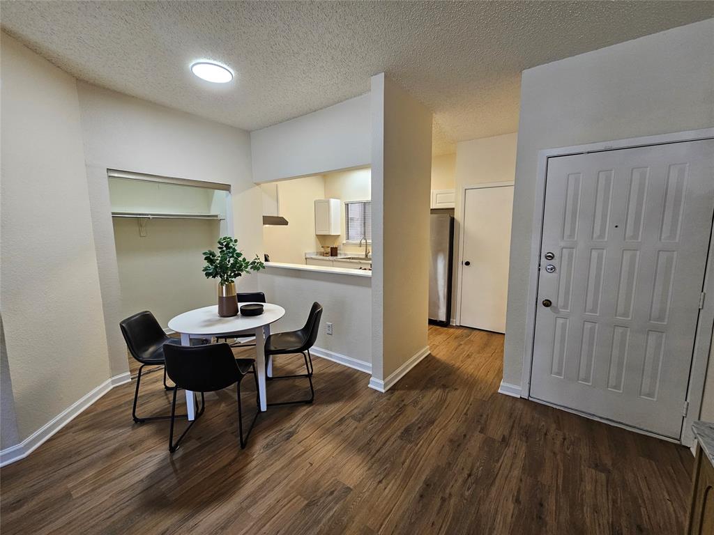 5550 Spring Valley Road, Unit C14 Dallas, TX 75254 - Photo 6 of 21 Open-concept living space featuring wood-finish flooring, recessed lighting, and a kitchen pass-through