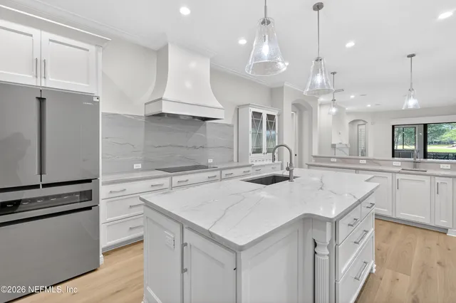 a view of kitchen with kitchen island wooden floor center island and stainless steel appliances