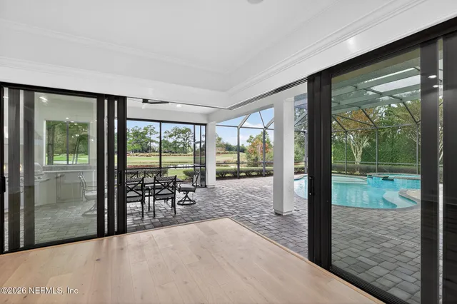 an empty room with wooden floor ceiling fan and windows