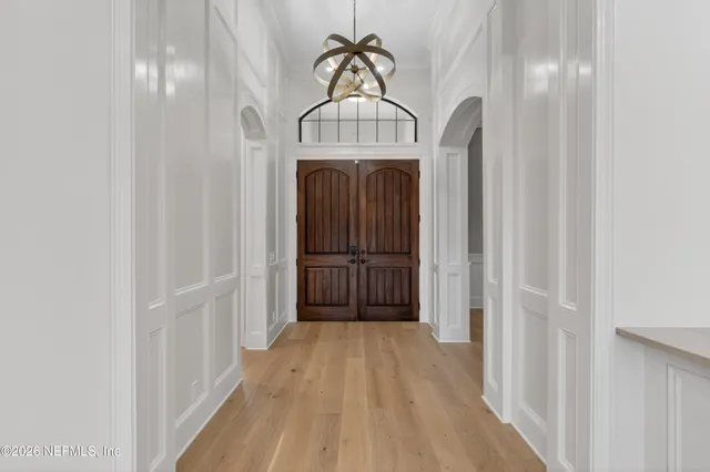 a view of hallway with a large window and wooden floor