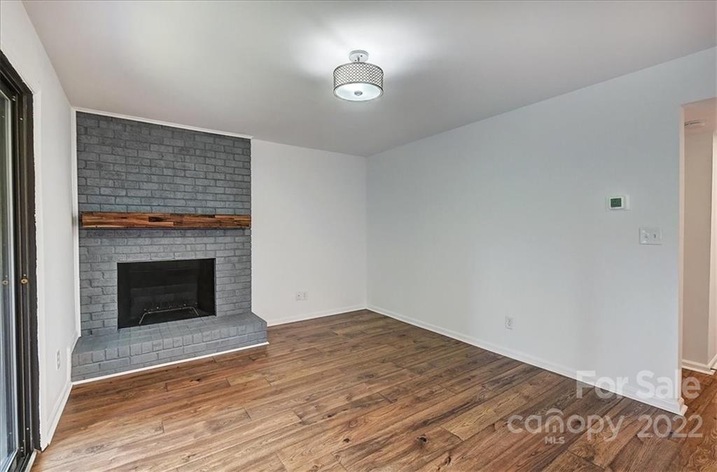 11019 Running Ridge Rd. Charlotte, NC 28226 - Photo 13 of 31 a view of empty room with wooden floor and fireplace