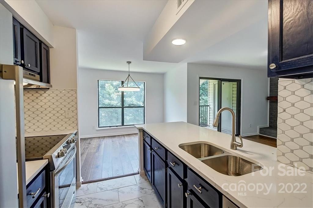 11019 Running Ridge Rd. Charlotte, NC 28226 - Photo 5 of 31 a kitchen with granite countertop a sink stove and cabinets