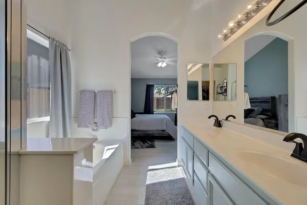 a spacious en suite bathroom with a double vanity sink and a mirror