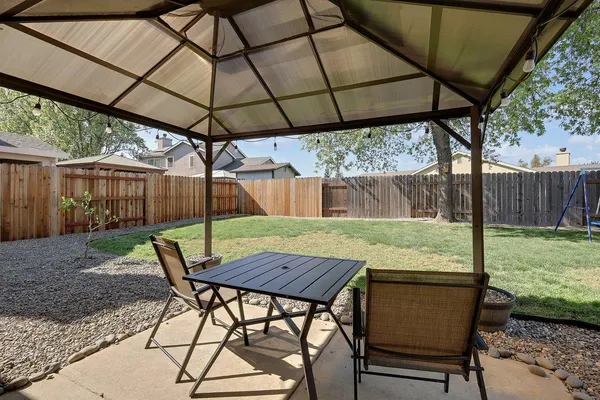 a view of patio with table and chairs under an umbrella