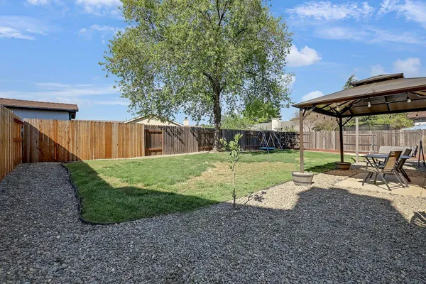a view of a house with backyard and sitting area