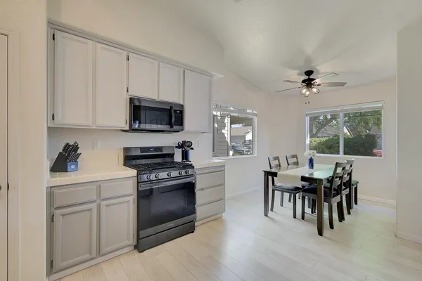 a kitchen with granite countertop cabinets stainless steel appliances and dining table