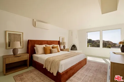 a bedroom with double bed and a large window