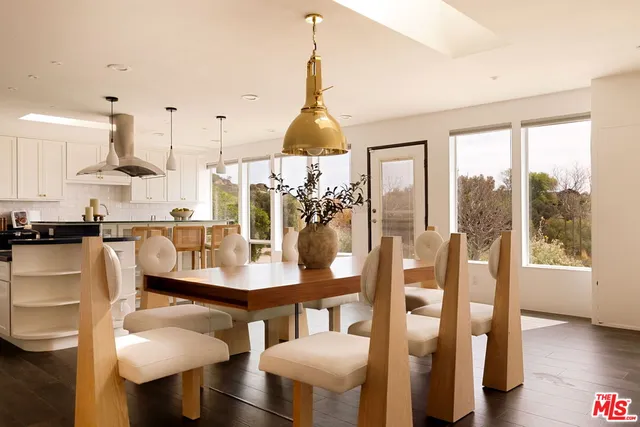 a dining room with furniture a chandelier and wooden floor