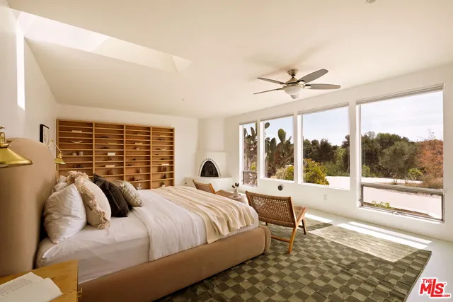 a bedroom with a bed and a large window with balcony view