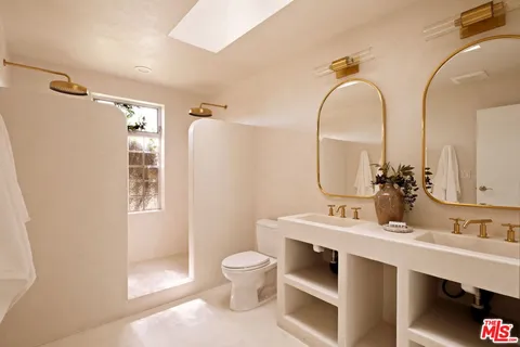 a bathroom with a sink mirror vanity and toilet