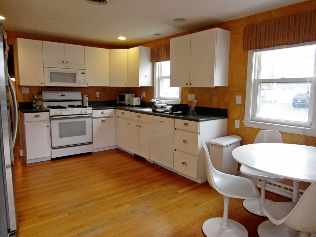 15 Yale Road Needham, MA 02494 - Photo 4 of 5 a kitchen with stainless steel appliances granite countertop a table chairs sink and cabinets